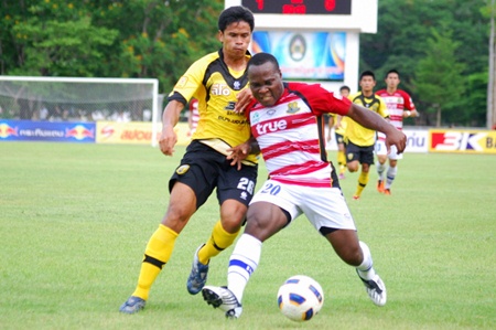 Pattaya United striker Ludovick Takam (20) shields the ball from a Khon Kaen defender during the first half of their match at the Rajabhat University Stadium in Mahasarakham, Sunday, May 22. (Photo/Ariyawat Nuamsawat) 