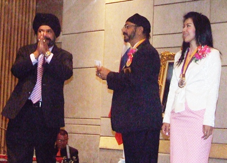 Past President Lion Saranjit Sachdev (left) makes a monetary donation to his younger brother President Montri to use in service projects.