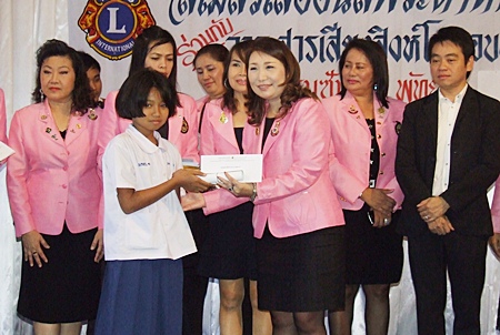 Rungthip Suksrikarn, president of the Lions Club of Pattaya-Pratamnak, distributes scholarships to deserving children. 