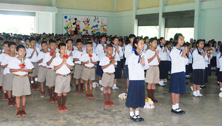Students recite a Buddhist prayer and wai khru chant, which expresses respect and gratitude for the teachers and asks for their blessing of the students’ studies.
