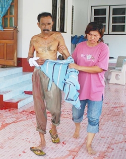 Mana Testrit is led away from his house to receive treatment from bites received from pet Golden Retriever “Peter” (back, left). 