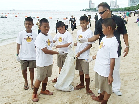 Youngsters and staff pick up trash off Pattaya Beach.