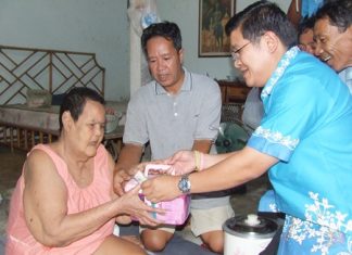(L to R) Buoy Kritthawin, and her son Chairat accept help from Deputy Mayor Verawat Khakhay and the mobile medical team.