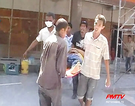 Workmates and volunteers help take the injured man to hospital. 
