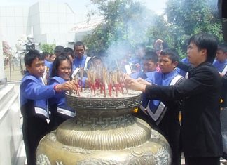 The young band members join in the ceremony by lighting and placing joss sticks in the ceremonial urn in front of City Hall.