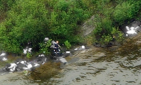 This photo, digitally altered to protect the identities of the victims, was taken from a helicopter above Utoya Island near Oslo, Norway.  It shows what police believe is the alleged gunman walking among victims after opening fire on a youth retreat, killing at least 86, Friday, July 22, 2011. The mass shootings are among the worst in history. With the blast outside the prime minister’s office, they formed the deadliest day of terror in Western Europe since the 2004 Madrid train bombings killed 191. (AP Photo/NRK, Marius Arnesen via Scanpix) 
