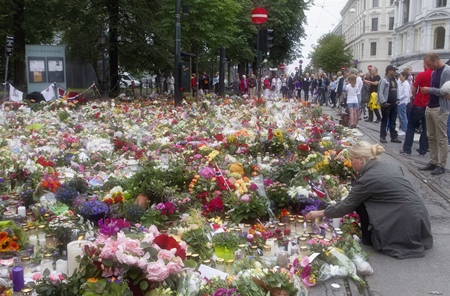 A woman places flowers amongst candles and other floral tributes in memory of the victims of Friday’s bomb blast and shooting massacre in Oslo, Norway. (AP Photo/Scanpix Norway/Berit Roald/Scanpix Norway) 