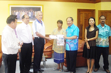 William Macey (center left), representing the Pattaya Sports Club, makes a donation to Mayor Mai Chaiyanit, Nongprue deputy mayors and family to assist families in need.