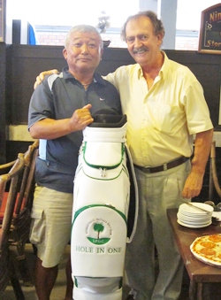 Yasuo Suzuki (left) is presented with his hole in one prize bag by Stephen Beard.