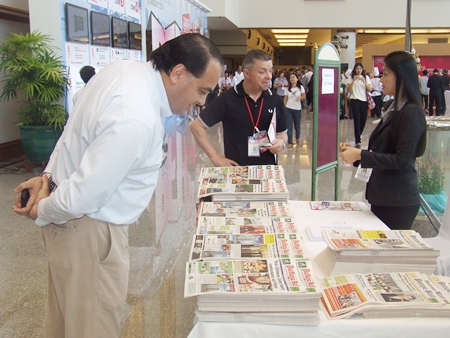 Guests pour over the latest edition of the Pattaya Mail at our booth during the expo.