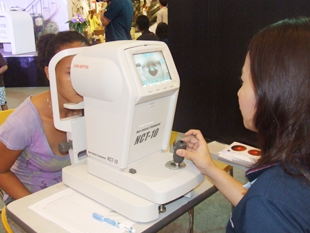 A Central Festival Pattaya Beach shopper is given a free eye check during Bangkok Hospital Pattaya’s health fair. 