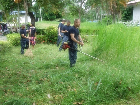 This is not an easy lawn to mow - sailors help tidy up the grounds at the Guranyawet Home for the Disabled in Banglamung.