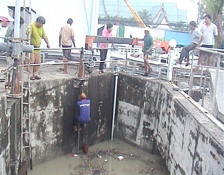Crews work to clear the debris from the drainage canal near Bali Hai pier.