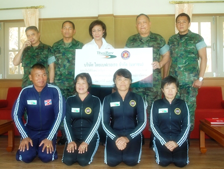 Charlotte Donavanik (back row, 3rd left), chief spokeswoman for Thai Beverage Co., donates 800,000 baht to Lt. Pongsak Phuriroj, director of the navy’s skydiving team. 