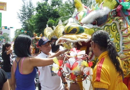 Feeding money to the dragon for good luck. (Photo by Phasakorn Channgam)