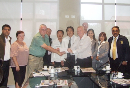 Gudmund Eiksund (centre right), president of the Rotary Club of Jomtien-Pattaya presents a cheque of 200,000 baht to Steve Graham, chair of the Pattaya Relief Group for use in the joint humanitarian relief effort. Standing center rear are city councilor Banlue Kullavanich, Sinchai Wattanasartsathorn and Deputy Mayor Ronakit Ekasingh.