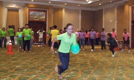 A green team member sprints across the floor in the balloon race.
