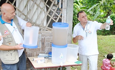 Rotarians Jan Abbink and President Carl Dyson demonstrate the simplicity of the drip filters and the purity of the filtered water.