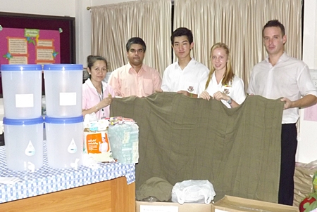 Tony Malhotra (2nd left) and Andrew Emerey (right) together with students from St Andrews brought life-saving water filters and Swiss International Air Lines blankets for the children.