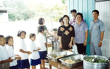 Picture shows Achana Snitwongse, Financial Director of Montien Pattaya (front,left),  Head Master Manoonn Kaewrung (extreme right), and staff from Montien Pattaya serving lunch and ice-cream to students of Ban Huay-kai-nao School.