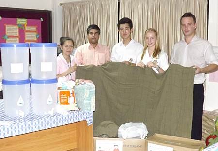 Tony Malhotra (2nd left) and Andrew Emery (right), together with students Sangjin and Jasmine from St Andrews brought life-saving water filters and Swiss International Air Lines blankets for the children.