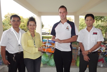 Andy Emery (2nd right) and two members of the SECURITAS staff donate necessities to Pinya Jumroonsan (2nd left) from the Rangsit Babies Home.
