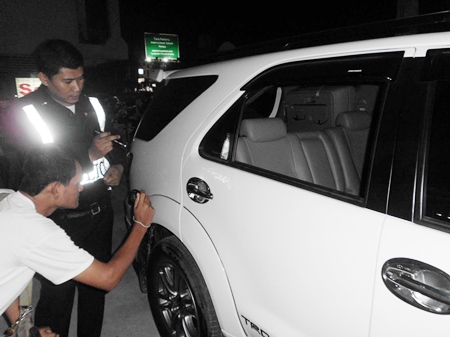 Police inspect and record the damage to Chukiet’s Toyota Fortuner. 