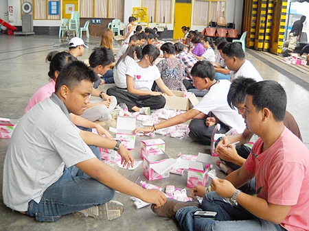 Flood victims taking refuge in Sattahip help pack relief supplies the Thai Red Cross can distribute to those still in peril.