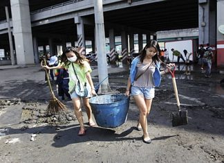 Volunteers carry a bucket full of mud during a clean-up drive after floodwaters receded from Bangkok, Saturday, Nov. 19. Hundreds of city workers, police, army personnel and civilian volunteers have been working to dig out the mud from previously flooded areas in the Big Mango. The situation has improved dramatically in recent days and cleanup has begun in many areas, though some still face weeks more under water. The government said 17 provinces remained flooded Sunday. They also said Sunday that the death toll has reached 602, the majority from drowning. (AP Photo/Altaf Qadri)