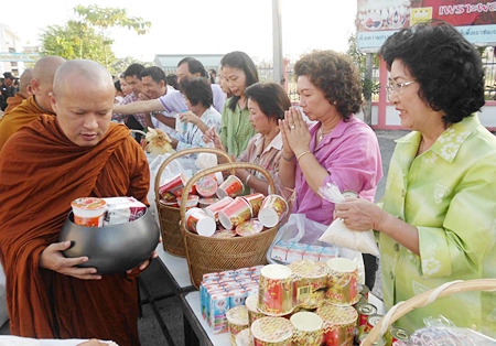 Good hearted Banglamung citizens fill monks’ bowls with much needed supplies to give to flood victims currently living in local shelters. 