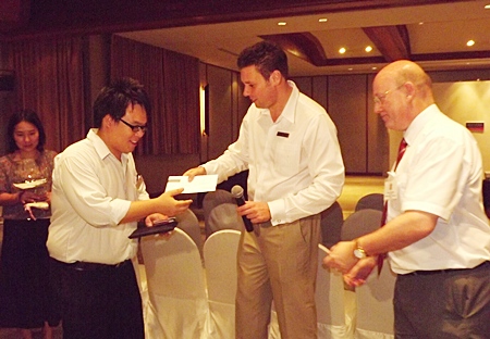 Clinton Lovell GM of the Aisawan Pullman presents the winner with his lucky draw prize.