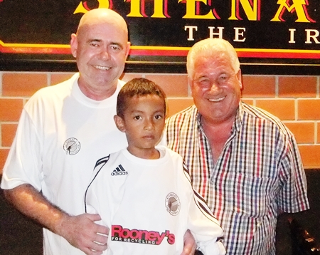 Former Gateshead and Blyth Spartans goalkeeper George Alberts and Shenanigans Manager Stewart Fraser have set up the first Gateshead Supporters Club in Asia at Shenanigans Bar in Jomtien.  Seen in the picture are George, Stewart and his adopted son Inn in Gateshead shirts ahead of this week’s 1st Round FA Cup match between Blyth and Gateshead.  Gateshead’s finest FA Cup run was ended 0-1 at home to Bolton Wanderers (the year of the Matthews Final) in a quarter final tie in 1953.  Gateshead beat Liverpool 1-0 in this remarkable FA Cup run. 