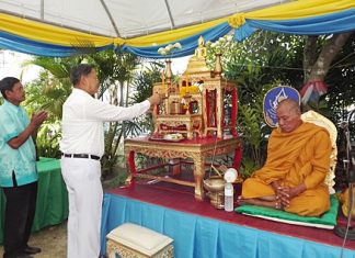 General Kanit initiates the prayer session by lighting the candles in front of the holy Buddha.