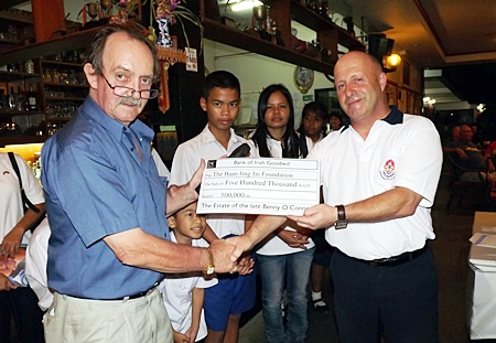 Alec Hoare (right) presents a cheque for 500,000 baht on behalf of the family of the late Benny O’Connor to Stephen Beard (left), to be donated to the Baan Jing Jai children’s home.