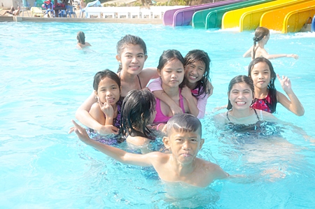 The youthful swarm of laughing splashers do what kids do and throw themselves into the pool.