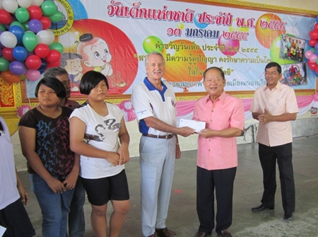 William Macy (3rd right), representing Pattaya Sports Club, presents a generous donation to Nongprue Mayor Mai Chaiyanit (2nd right) and Banglamung District Chief Chawalit Saeng-Uthai (right). 