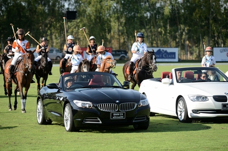 The pre-final parade is led from behind the wheel of a black BMW Z4 by Nunthinee Tanner, co-owner of the Thai Polo & Equestrian Club.