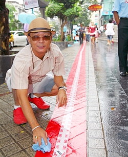 The red carpet along Silom Road is dotted with stickers, each representing a donated coin.