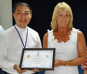 Pauline Fox receives a certificate of thanks form Father Peter, President of the Father Ray Foundation.