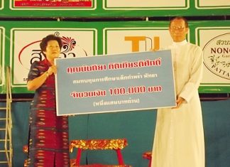 Feiyan troupe organizer Nanthiya Kittikiettisak presents orphanage Director Rev. Veera Phangrak with a donation of 100,000 baht.