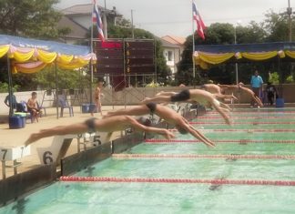 Young swimmers leap off the blocks at the start of a race.