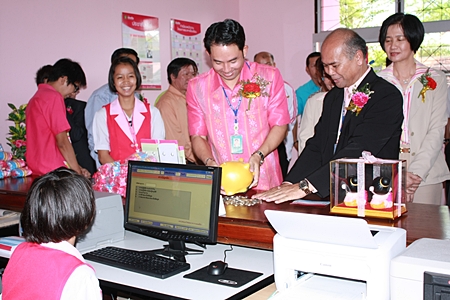 Mayor Itthiphol Kunplome breaks out his piggy bank to show students at Pattaya School No. 3 how to open a savings account. 