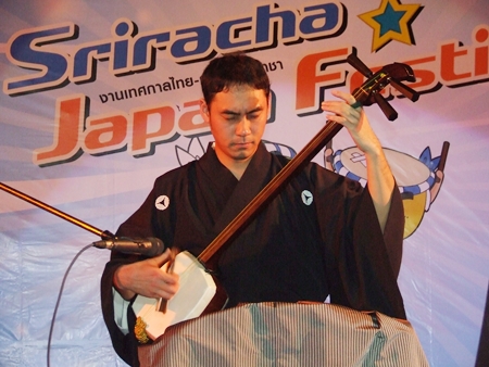A musician plays the traditional Shamisen (Japanese 3-stringed banjo).