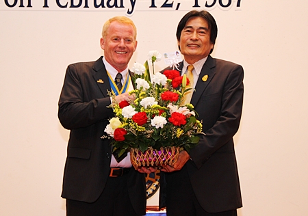 Deputy Mayor Ronakit Ekasingh presents a bouquet to President Gudmund Eiksund.