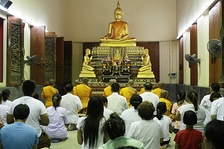 Faithful Buddhists pray and listen to monks chant on Buddhist All Saints Day at Wat Nong Prue.