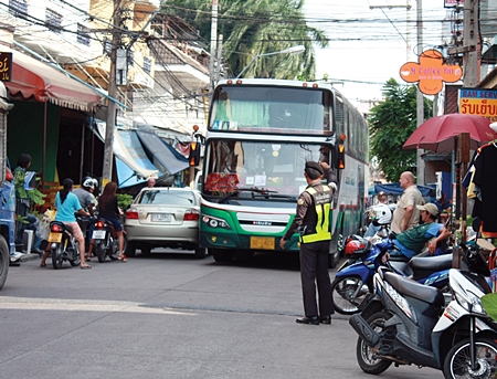 Some bus drivers still haven’t learned the size of their buses, and often attempt to drive them places where they don’t belong.  Here, municipal officer Kietinarong Panpra helps guide a large bus down a narrow soi.  For more on what municipal officers’ duties are in helping the city.