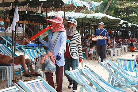 Vendors try to sell their wares to tourists on the beach.