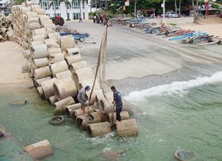 Workers prepare to load the concrete pipes onto a barge, which were then brought out to sea to become new homes for fish and coral.
