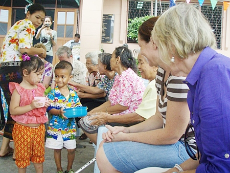 Children at the Fountain of Life prepare to pour water over visiting PILC members.