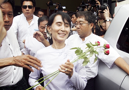 Myanmar pro-democracy leader Aung San Suu Kyi receives flowers from supporters as she leaves the headquarters of her National League for Democracy party in Yangon, Myanmar Monday, April 2. Suu Kyi claimed victory Monday in Myanmar’s historic by-election, saying she hoped it will mark the beginning of a new era for the long-repressed country. (AP Photo/Khin Maung Win)